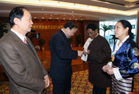 Sazhen (R), a doctor of the No.2 People's Hospital of Lhasa and also a member of the delegation of Tibetan deputies of China's National People's Congress (NPC), talks with a representative of local overseas Chinese in New York, the United States, March 18, 2009.