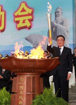Wu Bangguo, chairman of the Standing Committee of China's National People's Congress, lights the torch during the starting ceremony of the 11th National Games torch relay at the eastern gate of the Great Hall of the People in Beijing, capital of China, on Aug. 16, 2009. The 11th edition of the National Games, which are held every four years, will take place in Shandong Province from Oct. 16 to 28. (Xinhua/Pang Xinglei)