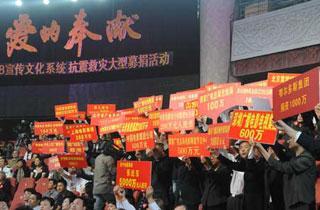 People hold placards on which are written with the number of money donated for the quake-stricken people of Sichuan Province during a benefit gala held in Beijing May 18, 2008.