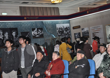 Visitors watch a documentary showing the past and present of Tibet at an exhibition marking the 50th anniversary of the Democratic Reform in Tibet Autonomous Region in Beijing, Feb. 25, 2009. 