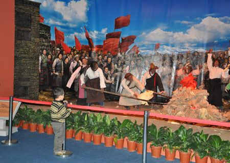 A boy watches a simulated scenario featuring serfs burning feudal documents produced in old Tibet after the Democratic Reform at an exhibition marking the 50th anniversary of the Democratic Reform in Tibet Autonomous Region in Beijing, Feb. 25, 2009.