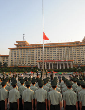 Armed Police watch as China's national flag flies at half-mast at a square in Xi'an, northwest China's Shaanxi Province, May 19, 2008. China on Monday begins a three-day national mourning for the tens of thousands of people killed in a powerful earthquake which struck the country's southwestern regions on May 12. 