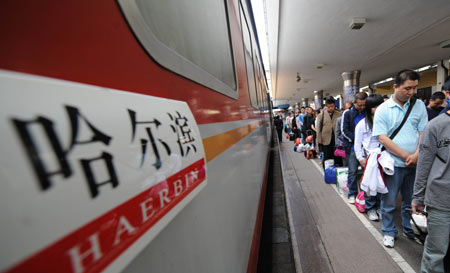 Passengers about to board a train mourn during a silent tribute at the platform of the Harbin Railway Station in Harbin, capital of northeast China's Heilongjiang Province, May 19, 2008. 