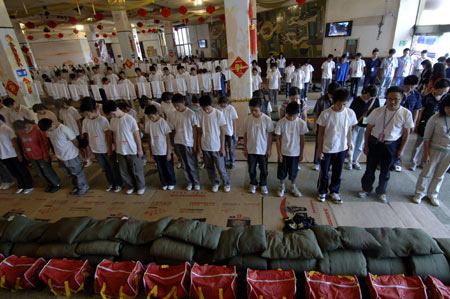 Quake survivors of Beichuan Middle School mourn during a silent tribute in Mianyang, southwest China's Sichuan Province, May 19, 2008. 