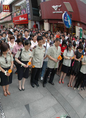 Citizens mourn during a silent tribute at a commercial walking street in Changsha, capital of central south China's Hunan Province, May 19, 2008. 